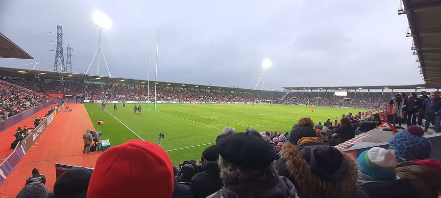 Le Stade Ernest-Wallon rempli de supporters un soir de match à Toulouse, vue depuis les tribunes sur le terrain et les tribunes d'en face