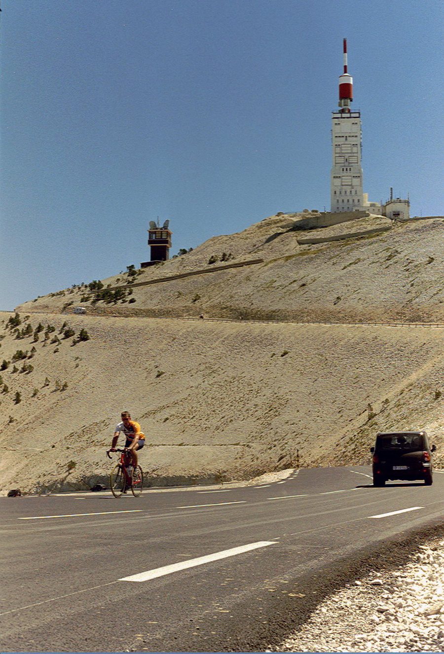 Le sommet du Mont Ventoux et sa tour météo, avec un cycliste grimpant la route
