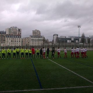 Deux équipes se saluent avant un match de district sur un terrain municipal