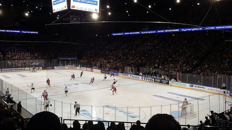 La patinoire de Bercy vue des tribunes pendant la finale de la Coupe de France de hockey sur glace, les joueurs des deux équipes sur la glace et les gradins remplis tout autour