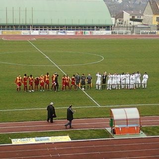 Deux équipes amateurs alignées avant le coup d'envoi d'un match dans un stade municipal français