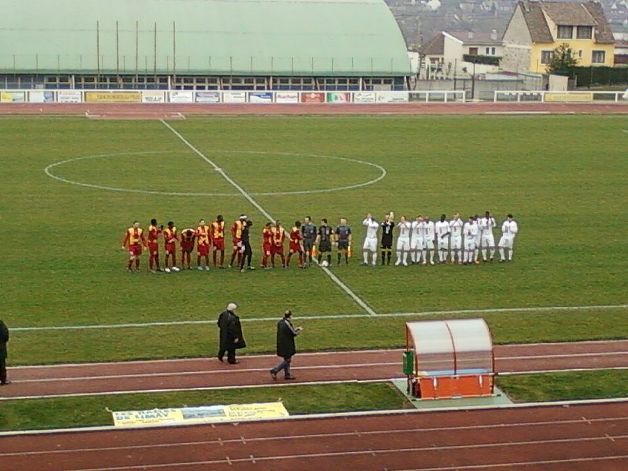 Deux équipes amateurs alignées avant le coup d'envoi d'un match dans un stade municipal français
