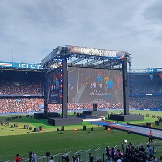 Tribune bondée et écran géant aux couleurs du Paris Saint-Germain avant un match au Parc des Princes