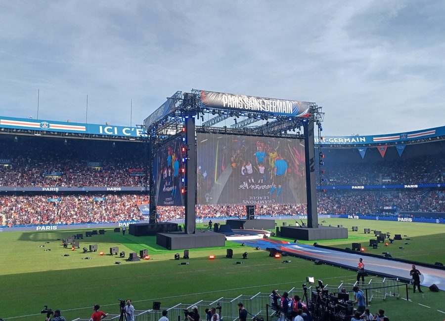 Tribune bondée et écran géant aux couleurs du Paris Saint-Germain avant un match au Parc des Princes
