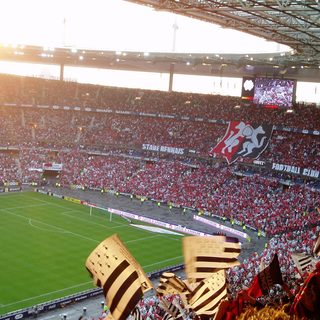 Tribune de supporters agitant des drapeaux lors d'une finale de Coupe de France