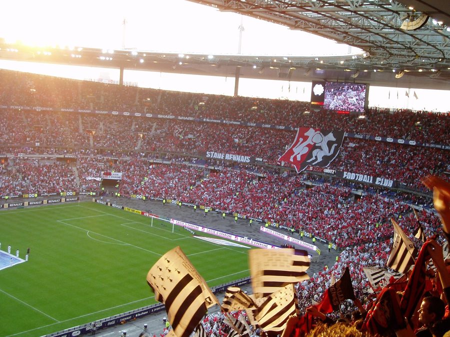 Tribune de supporters agitant des drapeaux lors d'une finale de Coupe de France de football