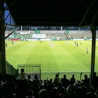 Vue d'ensemble du stade Bauer depuis la tribune couverte pendant un match de football en soirée