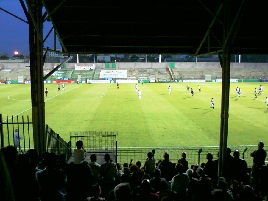 Vue d'ensemble du stade Bauer depuis la tribune couverte pendant un match de football en soirée