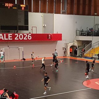 Échauffement des joueurs sur le parquet avant la finale du championnat de France de futsal, sous un panneau FINALE 2026 et un tableau d'affichage indiquant Laval