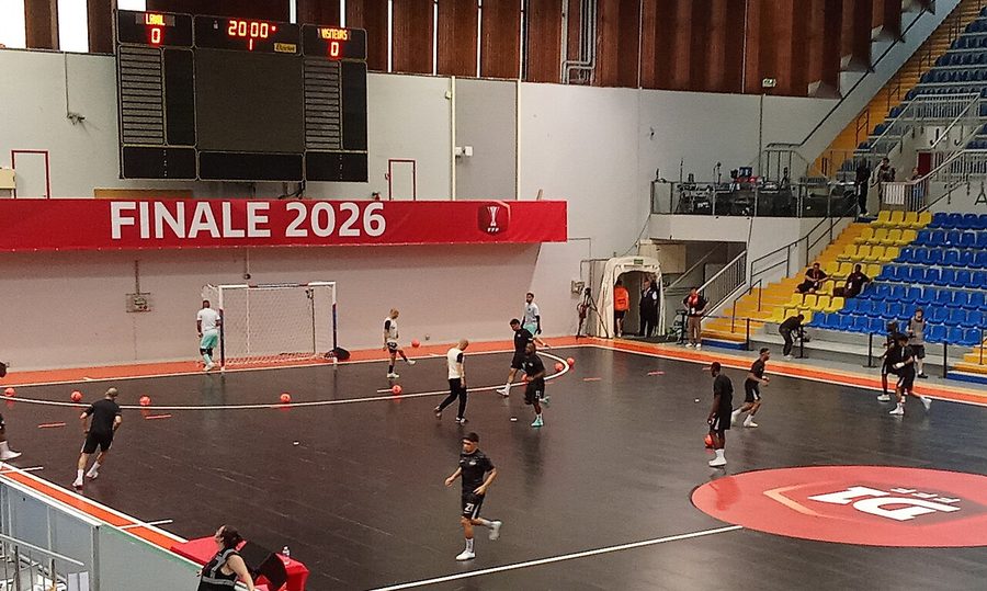 Échauffement des joueurs sur le parquet avant la finale du championnat de France de futsal, sous un panneau FINALE 2026 et un tableau d'affichage indiquant Laval