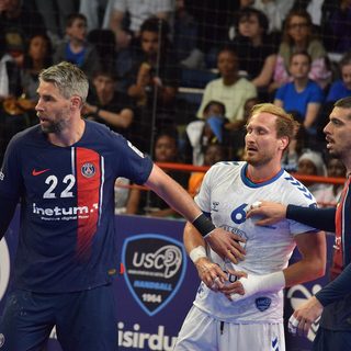 Des joueurs du Paris Saint-Germain et de l'US Créteil au contact devant le public pendant un match du championnat de France de handball