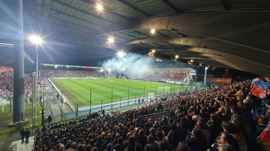Tribune garnie de spectateurs au stade Gaston-Petit de Châteauroux lors d'un match de football en nocturne